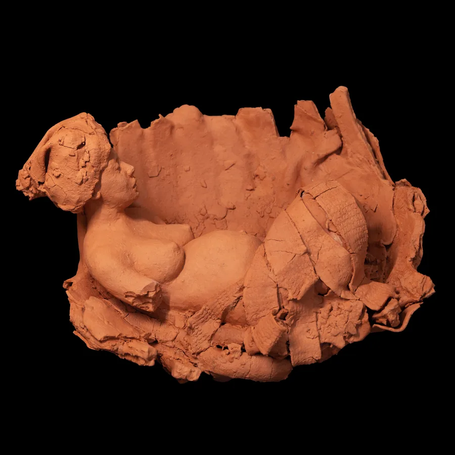 amai, the female figure lying inside the red stoneware vessel, seen from above