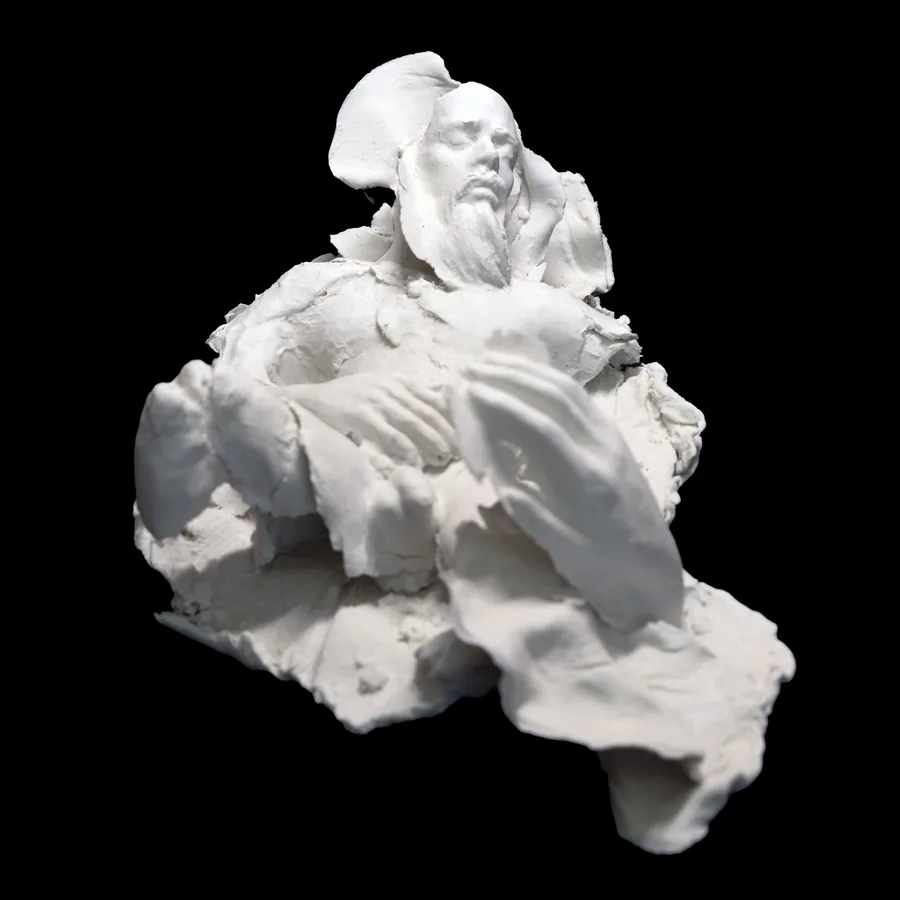 entropis, white porcelain figure of a bearded man with his head tipped back and hands folded, among torn sheets of clay
