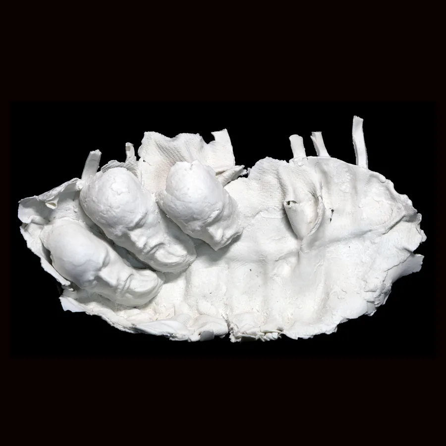 kairos, the three heads lying in the hollow of the white porcelain form, seen from above