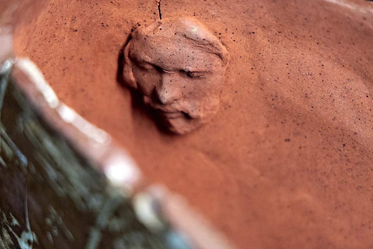 fan form 1, signature: a small face modelled in the red clay