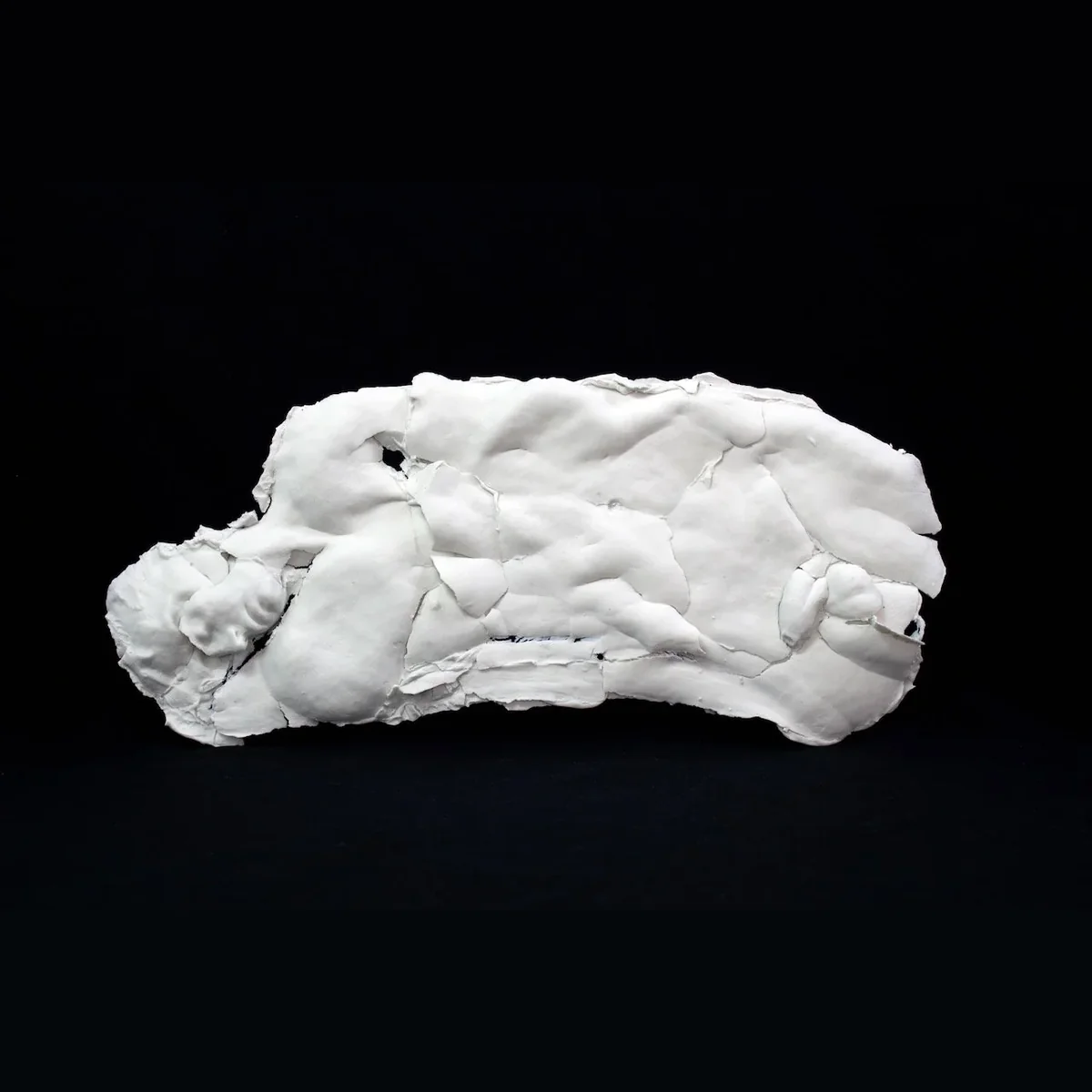 the full porcelain figure, a reclining body in white porcelain, cracked and layered